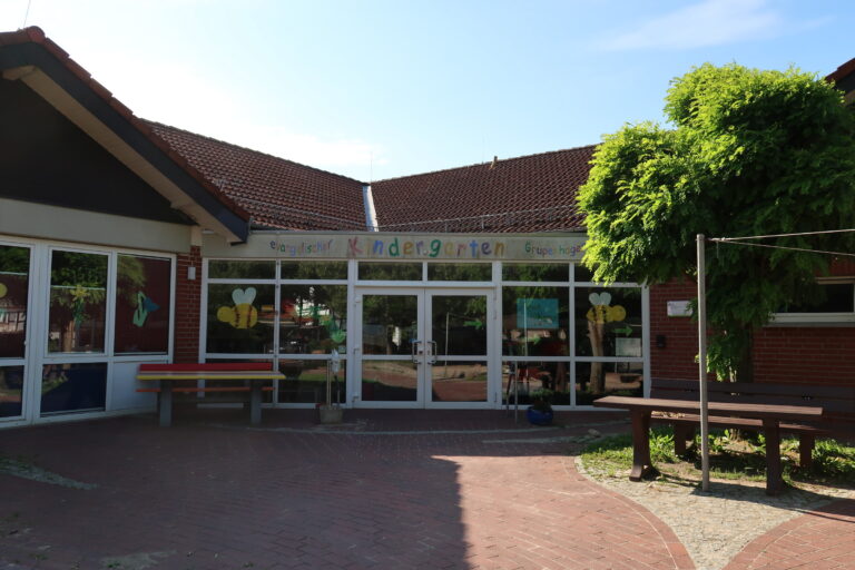 Das Gebäude der Kindertagesstätte "Kindergarten Grupenhagen", ein modernes, lichtdurchflutetes Gebäude mit einem sicheren Außenspielbereich für Kinder.