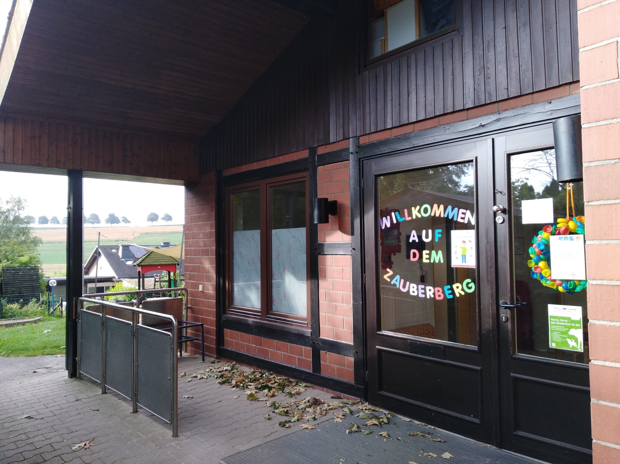 Die Kindertagesstätte "Zauberberg", ein gemütliches Gebäude mit einem grünen Garten und einem Spielplatz im Hintergrund.